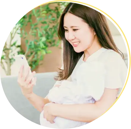 妊娠中のママがスマホを見ている画像